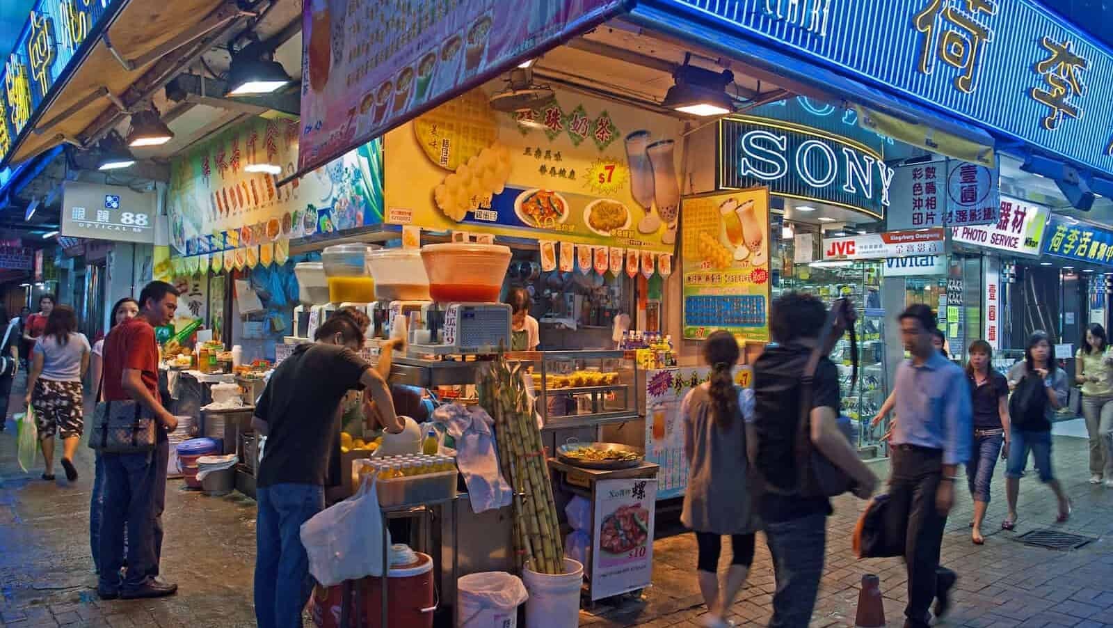 A typical street restaurant in Kowloon, Hong Kong, showcasing the vibrant food culture and the diversity of Asian cuisines, including Singaporean dishes