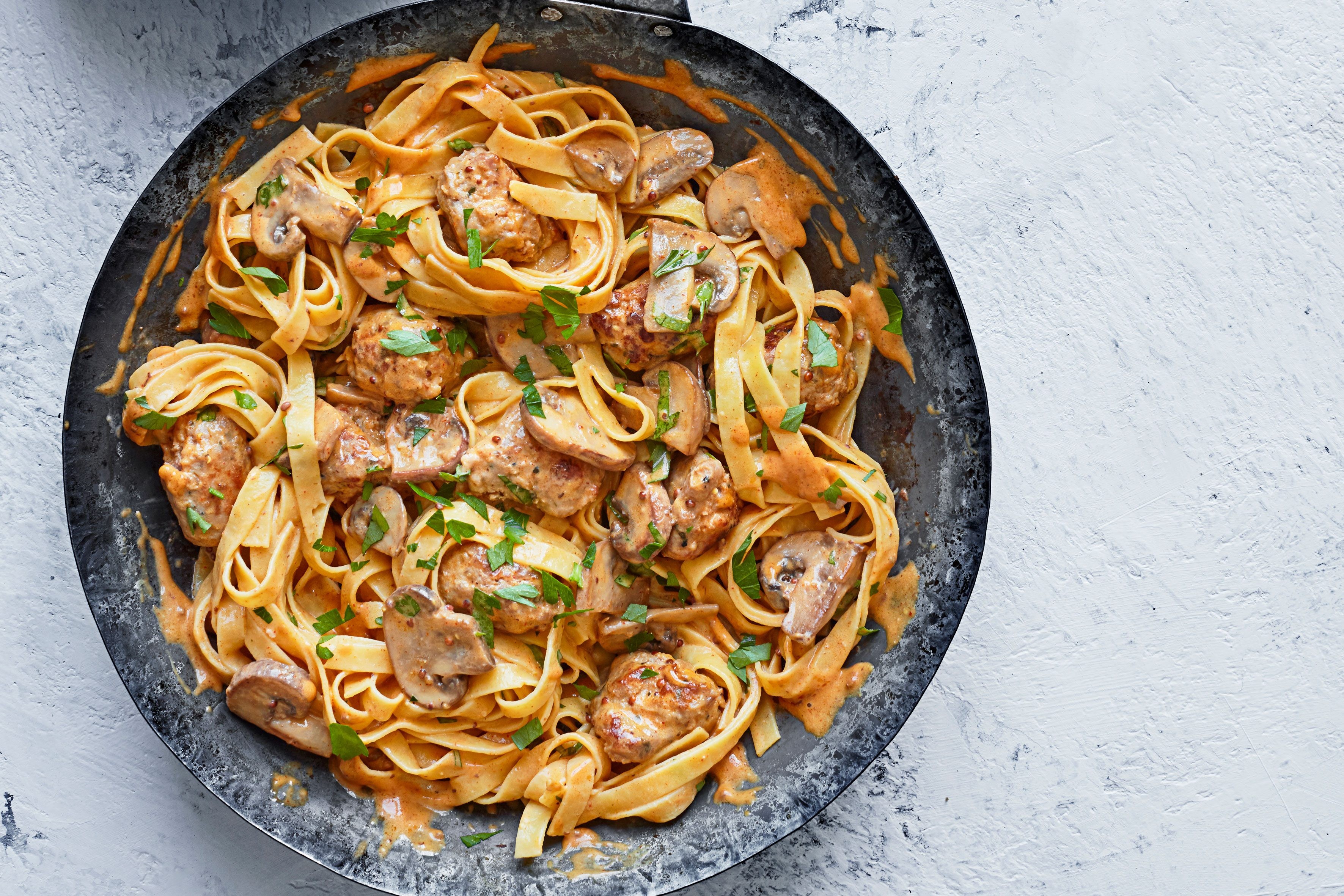 Tagliatelle in a pan with sausage, mushroom and parsley