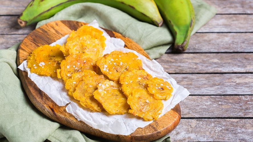 Dominican Tostones dish with fried and smashed plantains. Alt text: Tostones, a classic Dominican side dish, featuring twice-fried plantain slices that are crispy and golden brown.