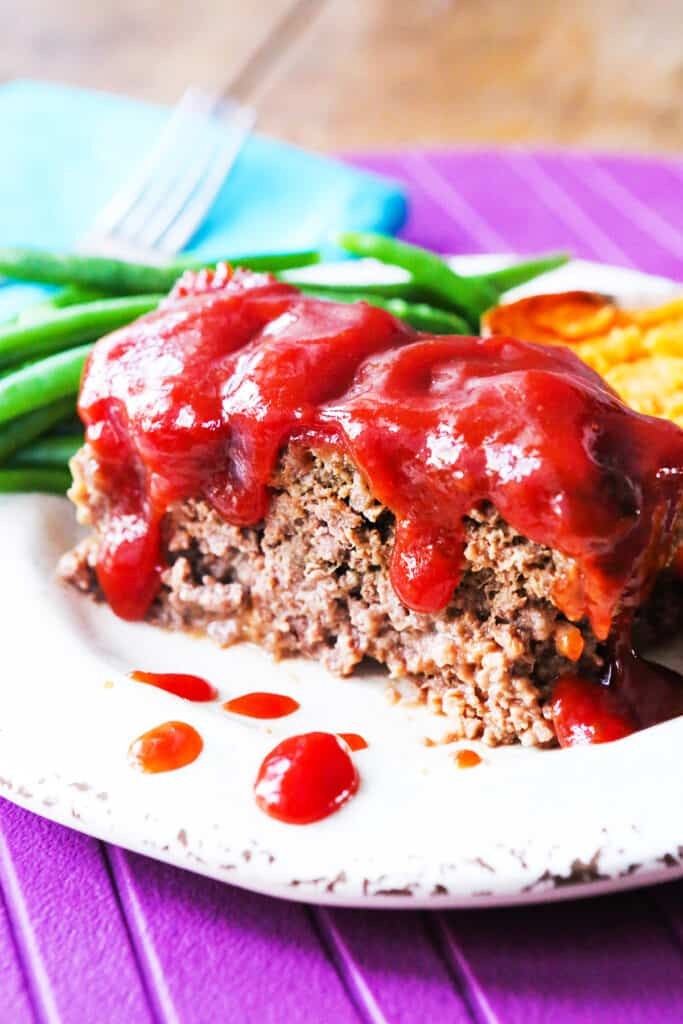 Meatloaf with a slice of cornbread and green beans.