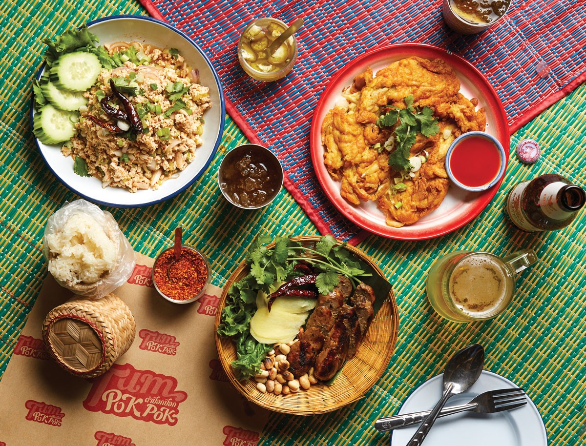 A vibrant display of fresh Thai ingredients, including galangal, lemongrass, and Thai basil.