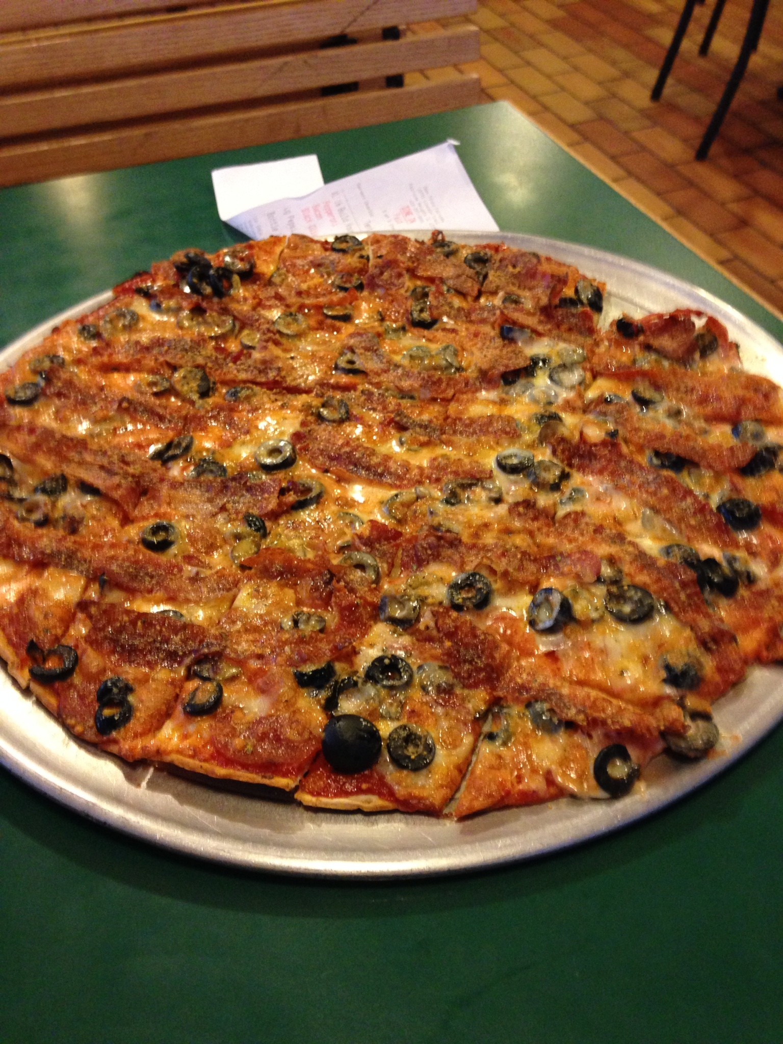 Close-up of St. Louis-style pizza with thin, crisp crust, Provel cheese, and square cut slices