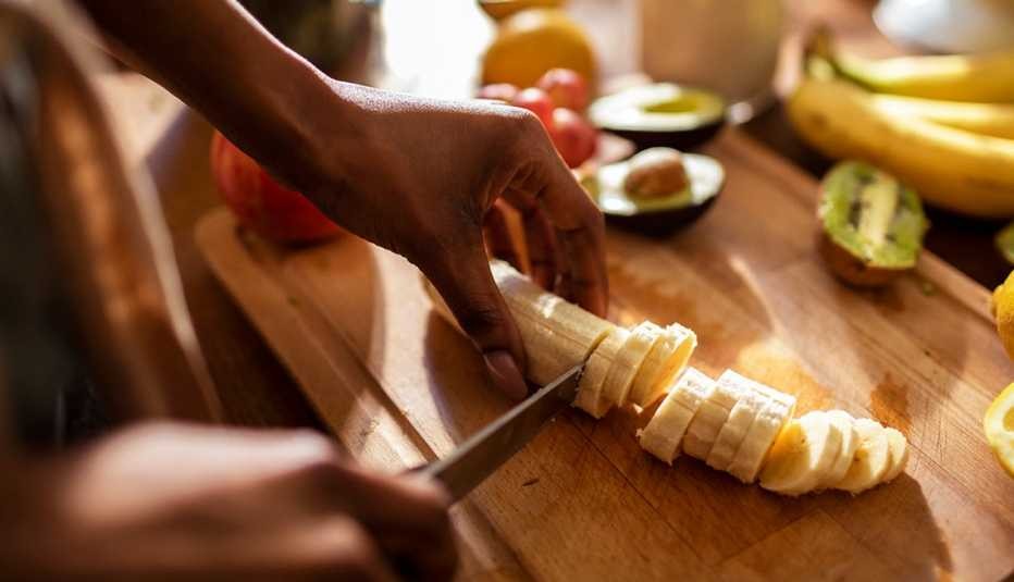 A close-up of a hand peeling a ripe yellow banana, showcasing its soft texture