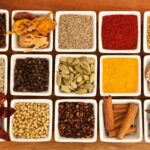 Assortment of vibrant Indian spices, including turmeric, cumin, coriander, and chili powder, commonly used in authentic Indian cooking
