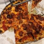 Frank Pepe's classic pepperoni pizza, perfectly charred and topped with fresh ingredients