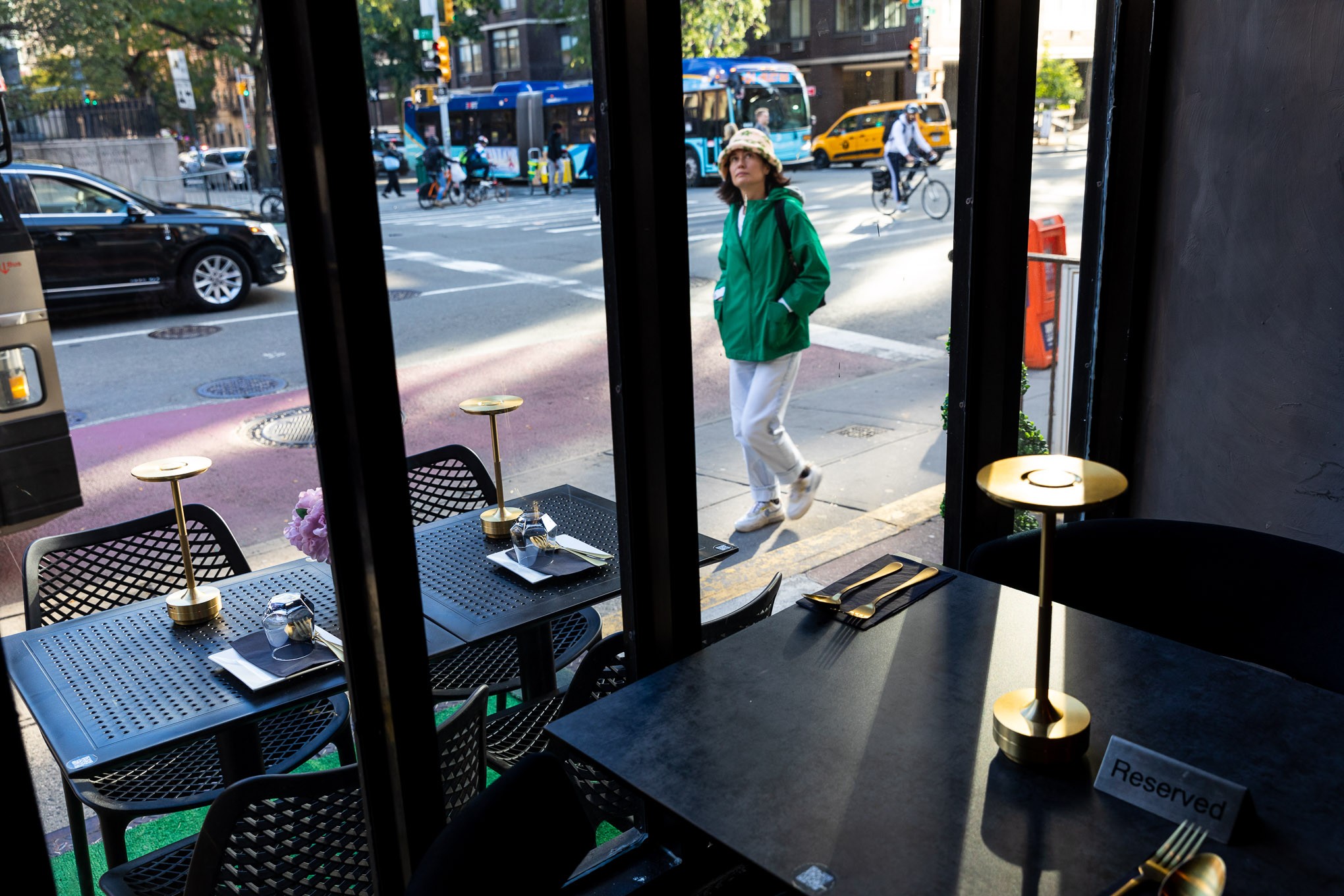 A person passing on the street looks up at Thai Food Near Me’s sign.