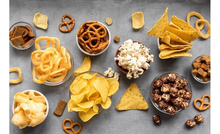 Assortment of slider foods like chips, popcorn, crackers, pretzels, and candy, showcasing their high sugar, fat, and carbohydrate content.