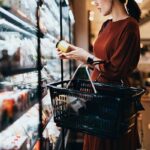 Woman in a grocery store carefully reading a product label
