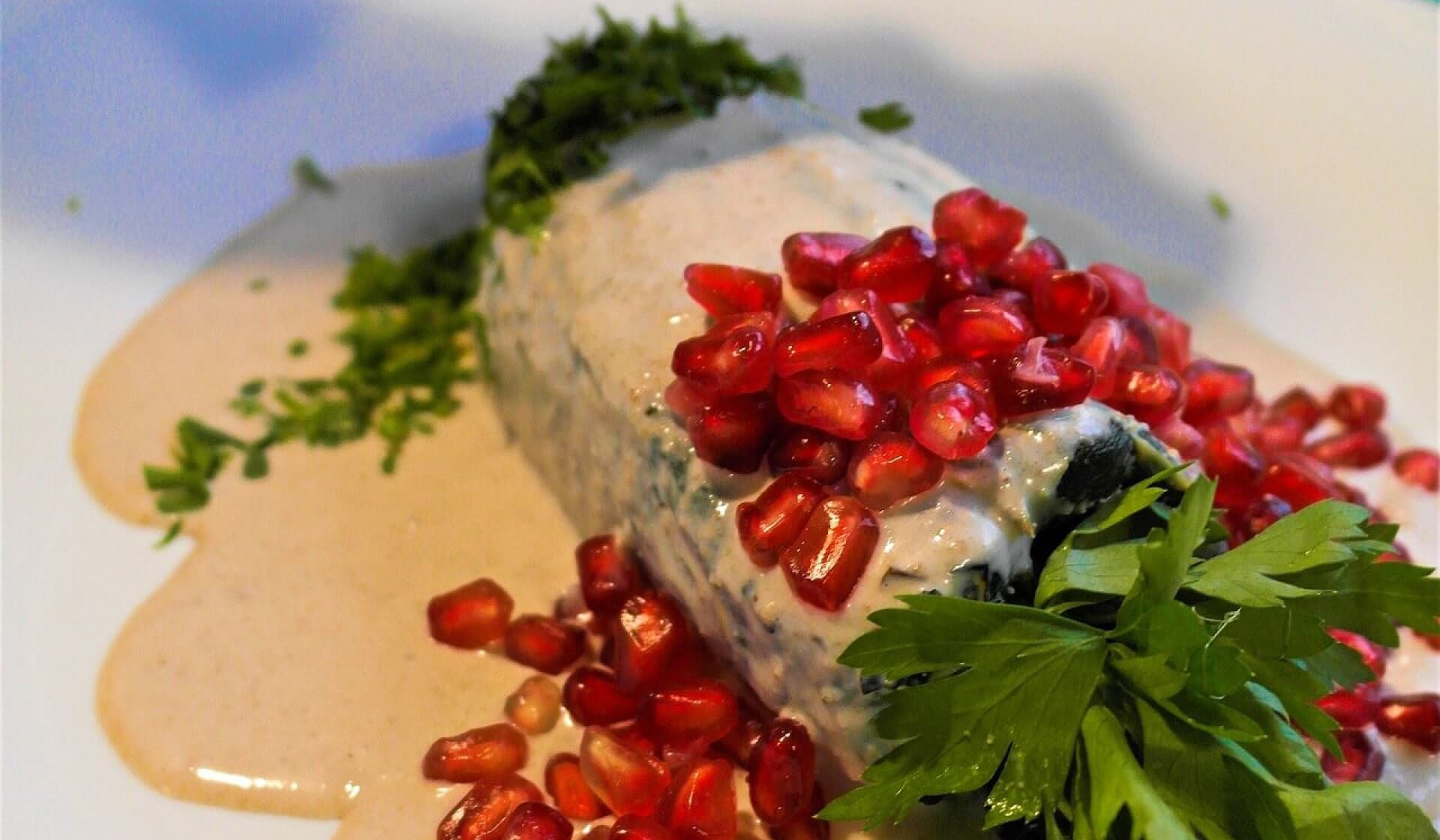 Chiles en nogada with walnut sauce and pomegranate seeds