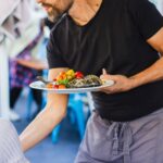 Food runner carefully transporting plates to customers