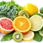 Colorful variety of fruits and vegetables containing vitamin c on white background