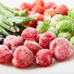 Frozen strawberries, brussels sprouts, green beans on a white plate