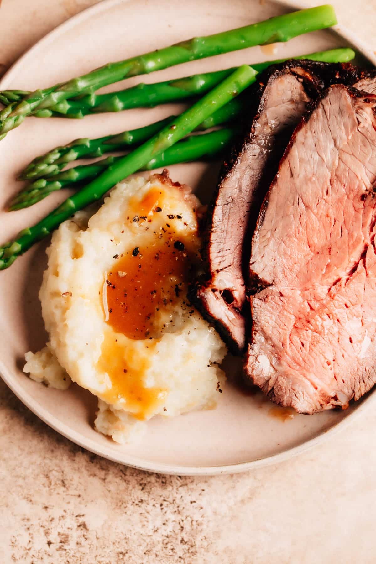 Grilled steak served with creamy mashed potatoes and a side of asparagus.