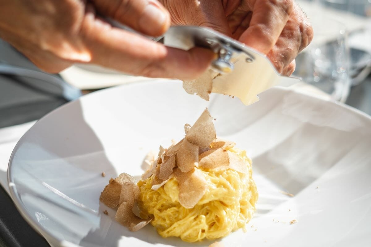 White Truffles Being Shaved on Top of a Bowl of Fresh Pasta