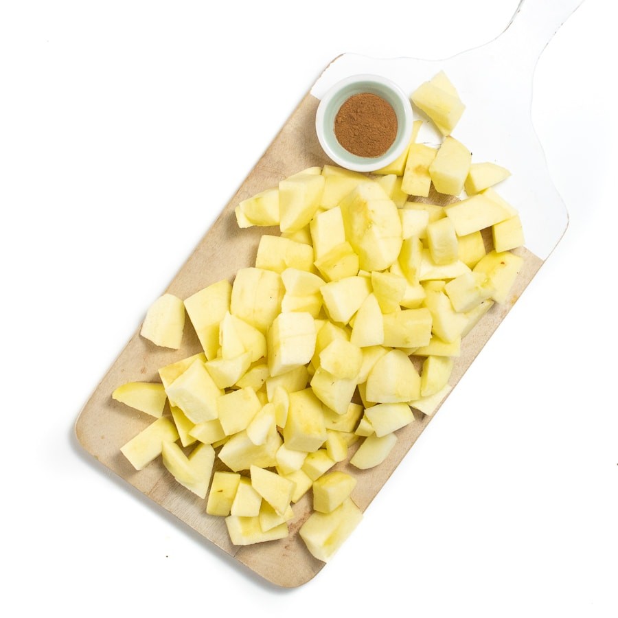 Chopped and peeled apples in a small bowl of cinnamon