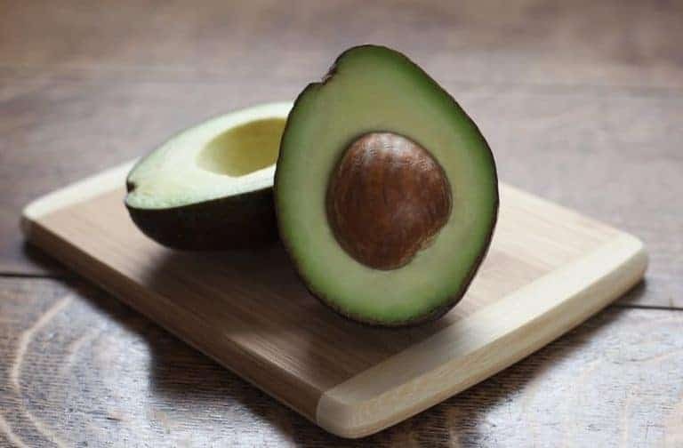 Popular Aussie food - avocado, showcasing sliced avocados on a wooden board, commonly enjoyed with breakfast in Australia.