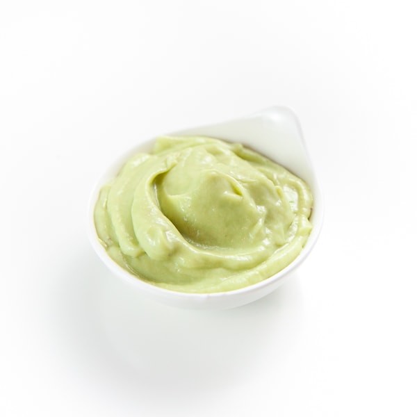 Bowl of Avocado and pea baby food puree.