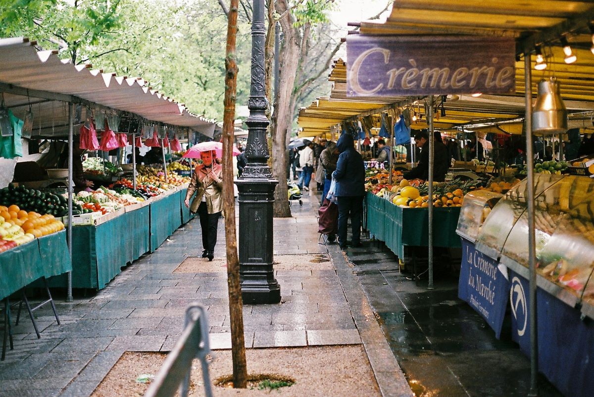 A bustling market scene with vendors selling fresh produce