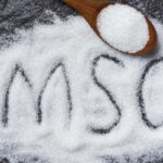 A close-up shot of MSG crystals on a spoon, showcasing its texture and color, highlighting its role in enhancing savory flavors and umami taste