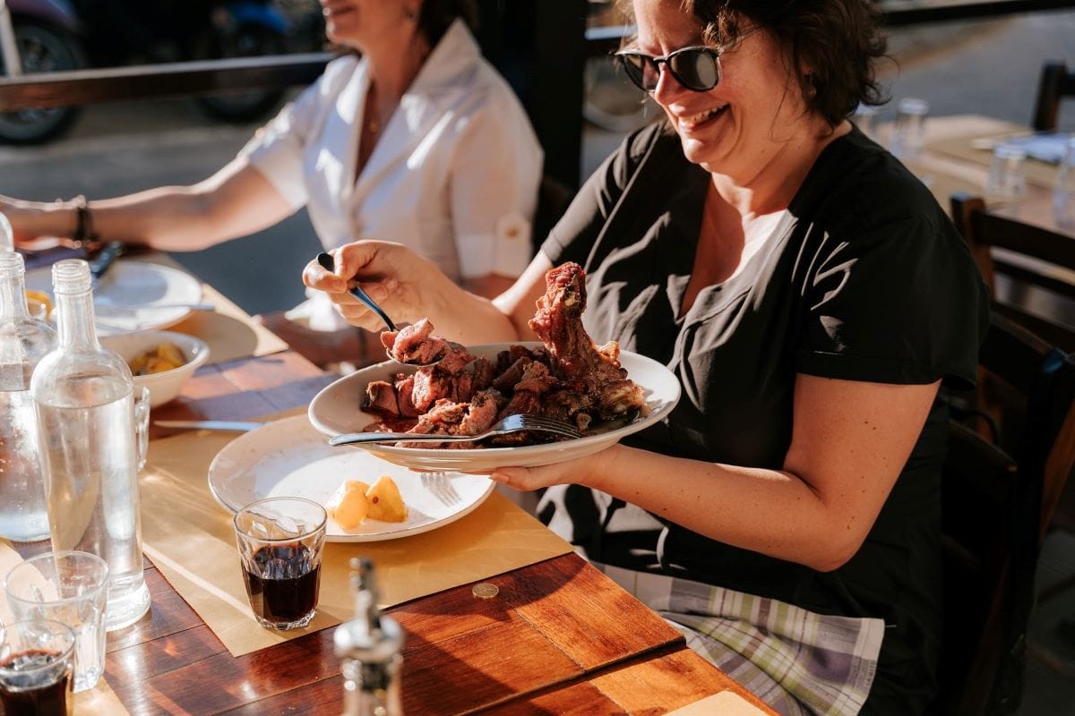 Woman Scooping Meat Onto Her Plate