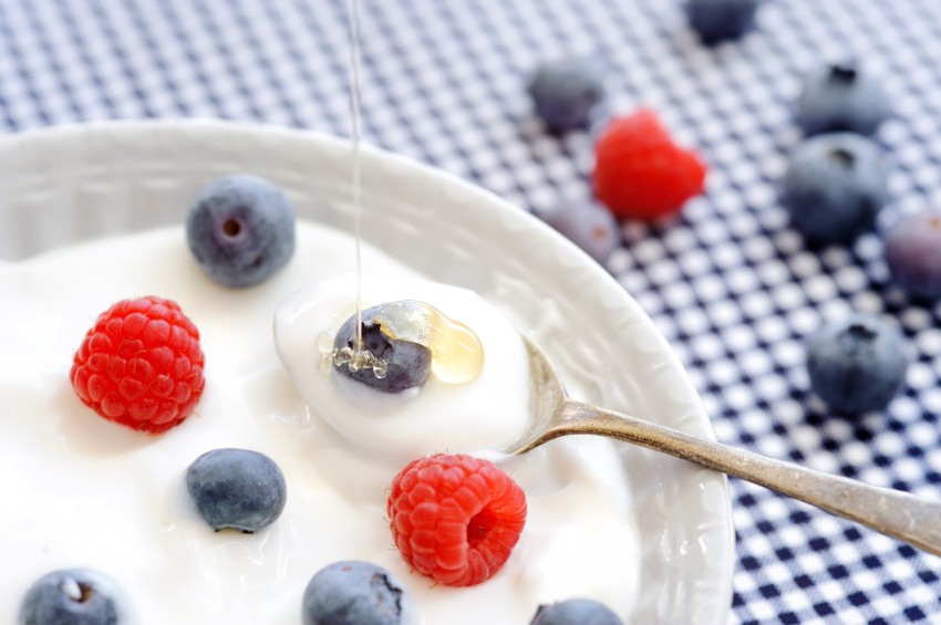 Close-up of a glass bowl of yogurt with blueberries, raspberries, and chia seeds