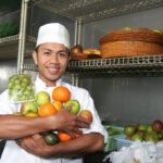 Chef placing fruits into a well organized storage shelf