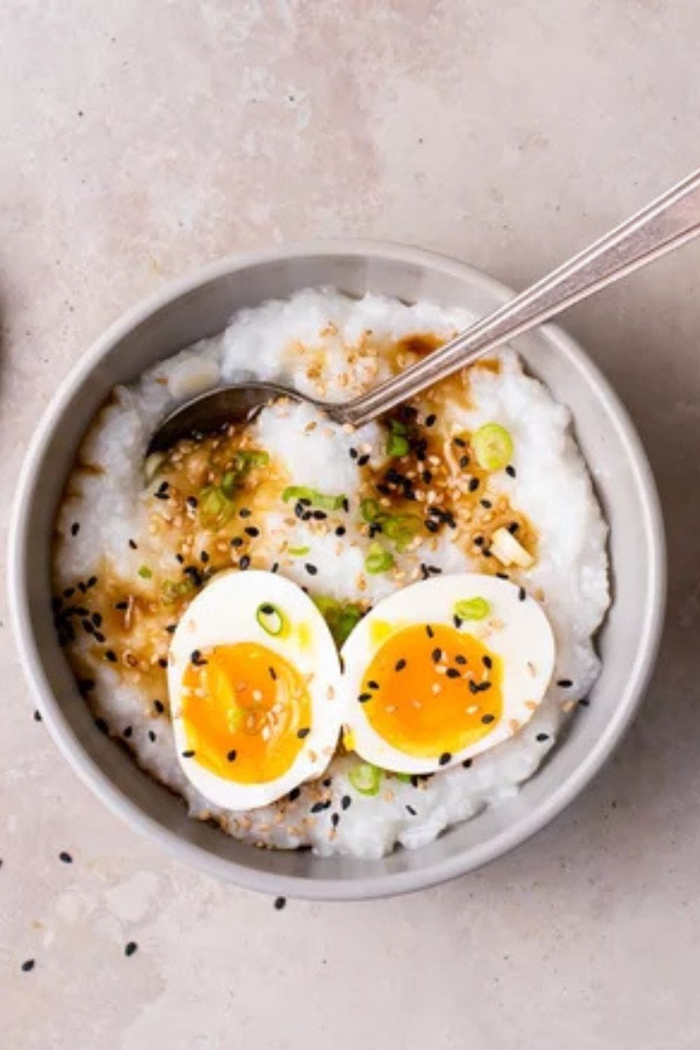 Classic Congee served with toppings like scallions and preserved duck egg, offering a comforting and nutritious start to the day
