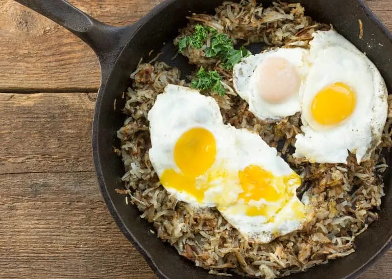 Eggs scrambled in a pan with toast on the side, showcasing a simple and quick breakfast or meal option.