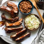 A delicious plate of ribs with various side dishes, showcasing a balanced meal.
