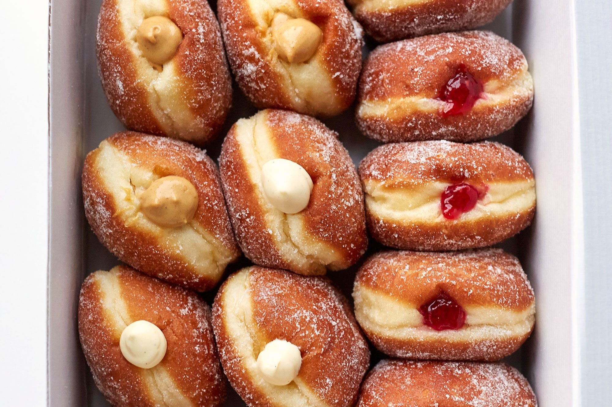 Jelly doughnuts filled with strawberry jam and dusted with powdered sugar