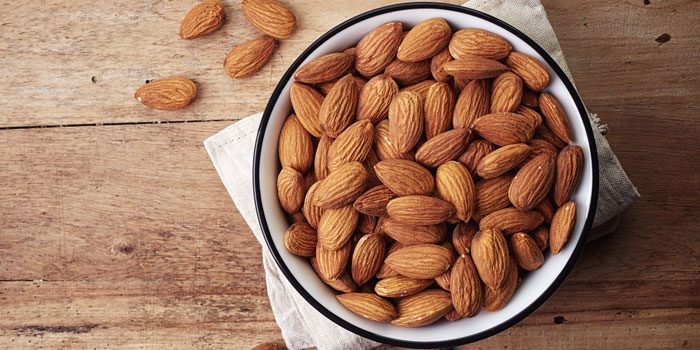 Selection of foods high in Vitamin E, including almonds and avocados
