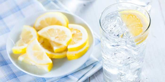 A glass of lemon water, promoting skin hydration