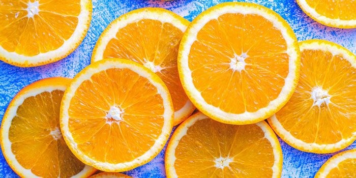 A colorful display of fruits and vegetables high in Vitamin C, including oranges and blueberries