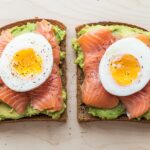 Avocado toast with eggs and salmon provides healthy fats, protein, and sustained energy to slow alcohol absorption