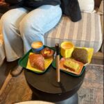 Variety of croissants and pastries on table by comfy sofas