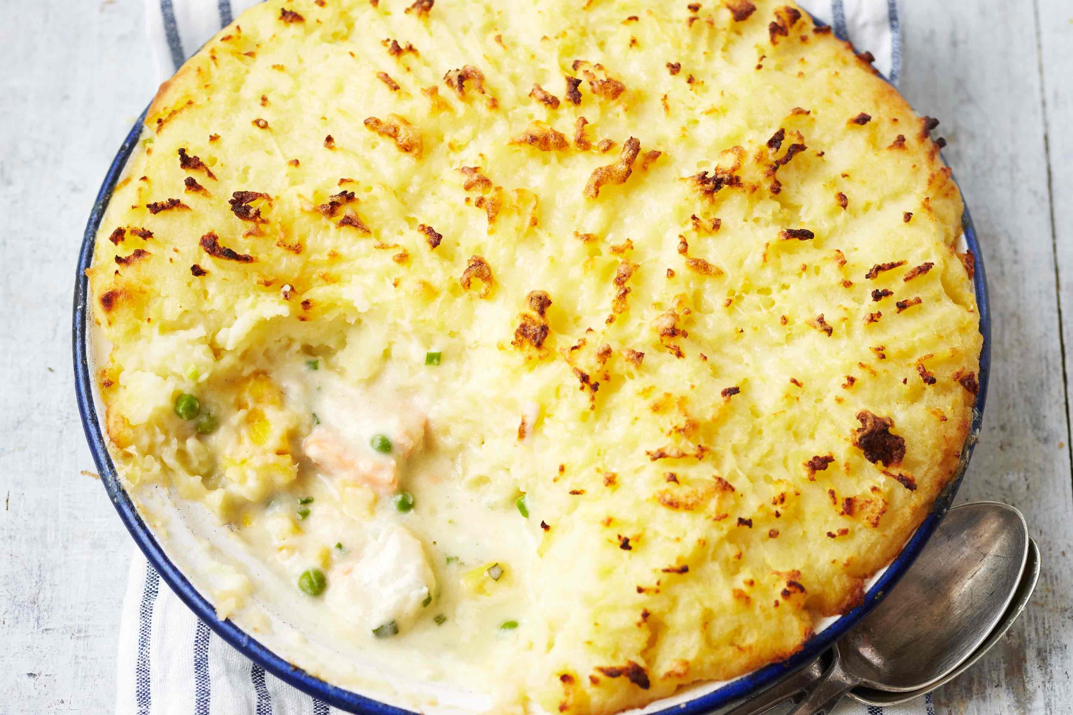 A close-up of a fish pie resting on a striped tea towel