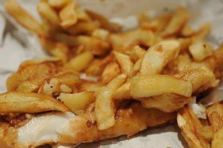 Fish and Chips, a classic takeaway meal featuring fried fish and chips, served with lemon and tartare sauce.