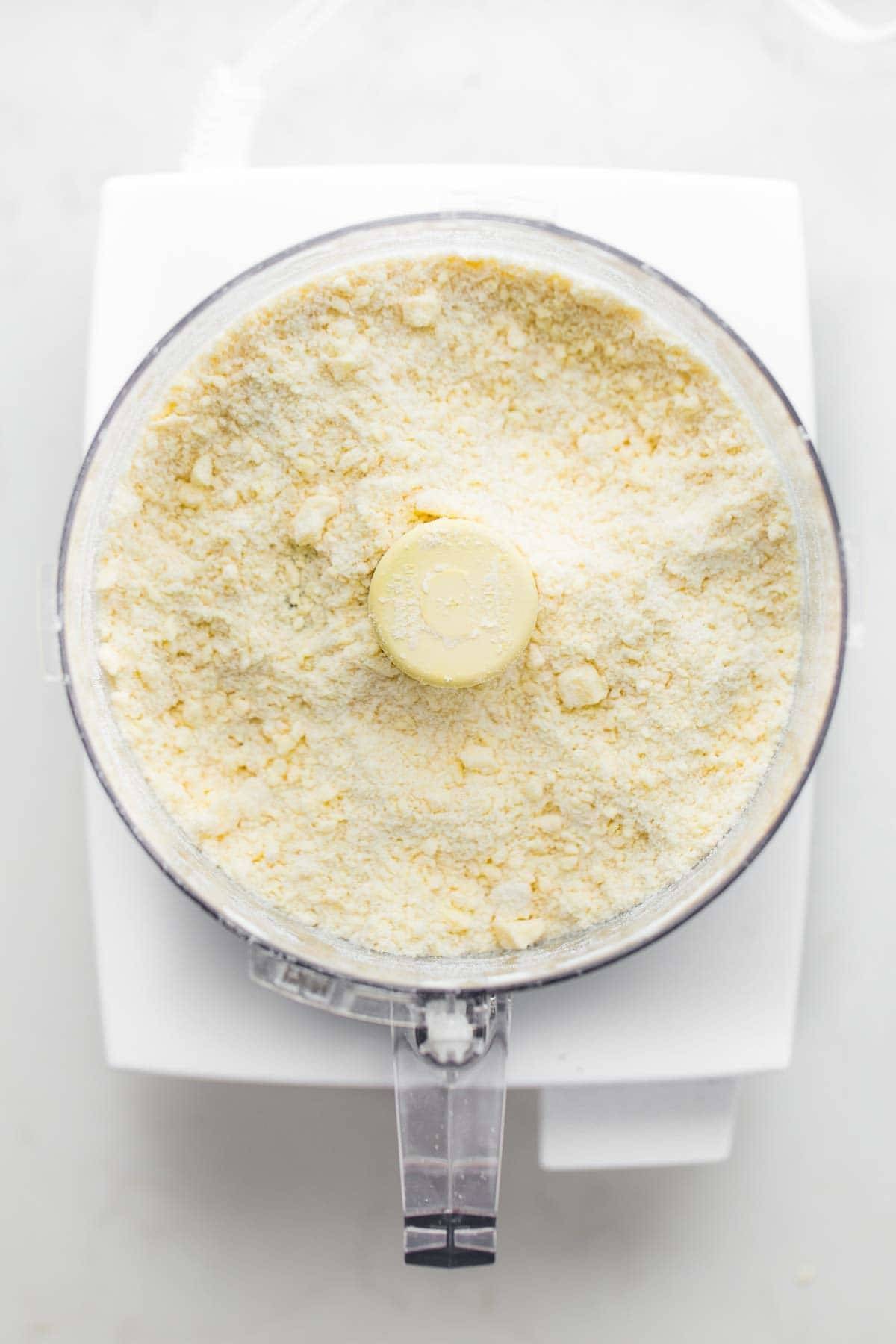 Pie crust dough being made in a food processor, highlighting its efficiency in baking preparations.