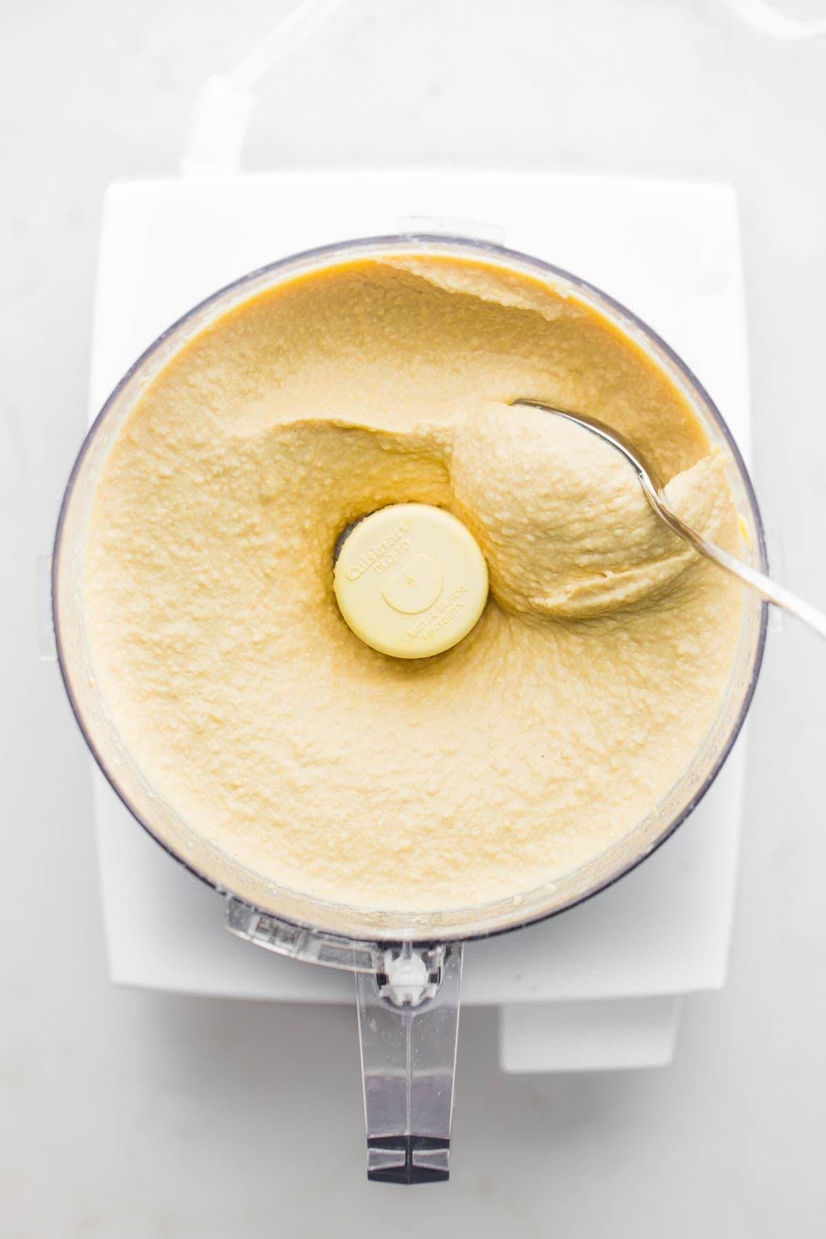 Smooth hummus being made in a food processor, showcasing the appliance's capability to create creamy dips.
