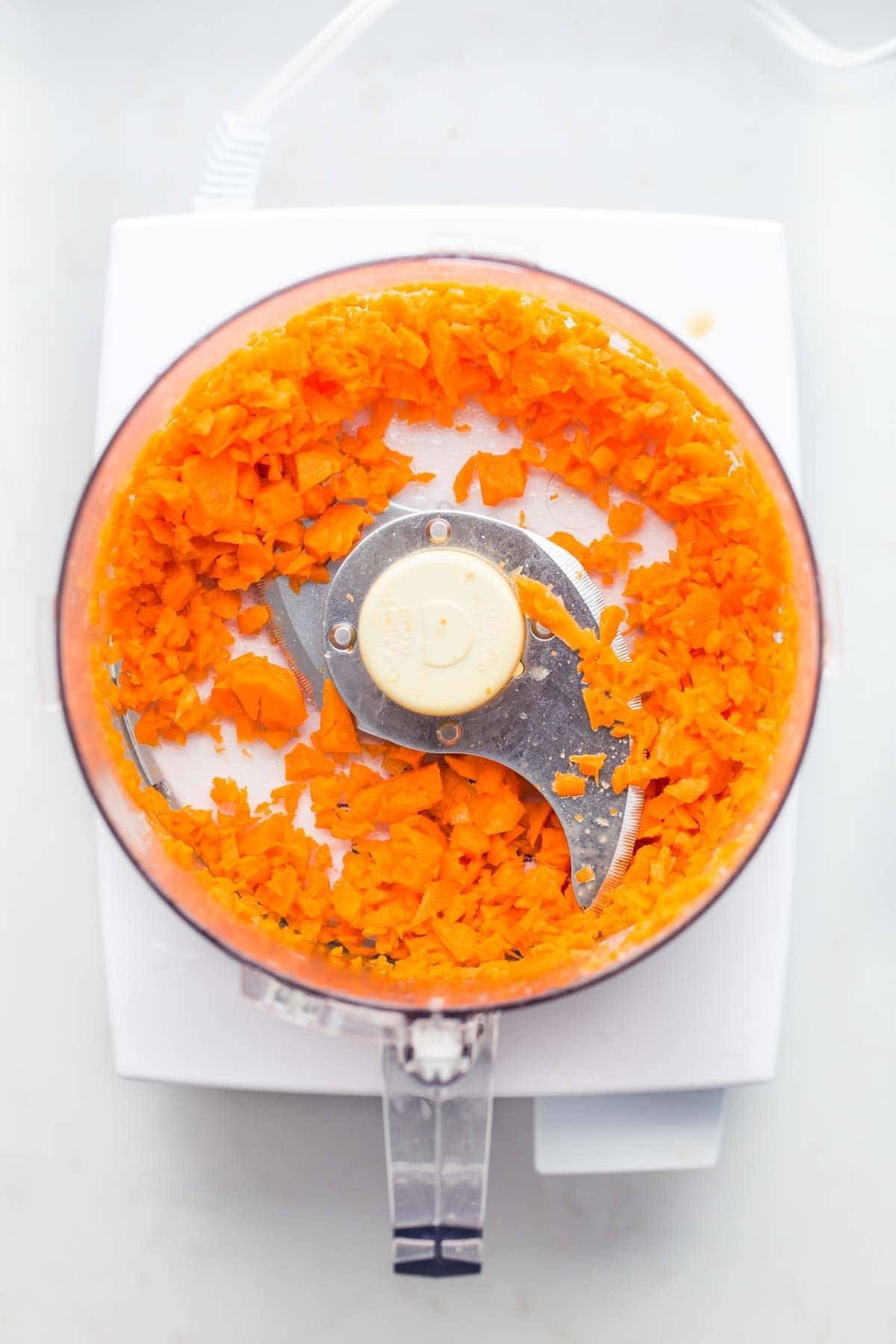 Vegetables being chopped in a food processor, demonstrating the appliance's efficiency in dicing and chopping tasks.
