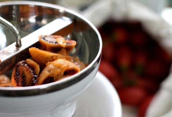 Close-up of apples being processed in a food mill