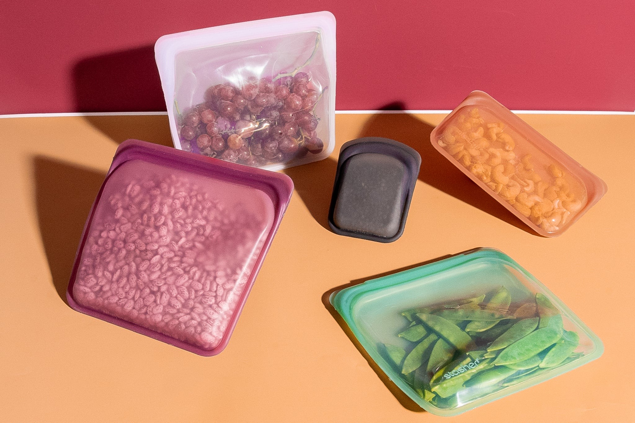 Several clear, heavy-duty freezer slider bags filled with colorful fruits and vegetables, showcasing their airtight seal and convenient slider closure for effective food preservation.