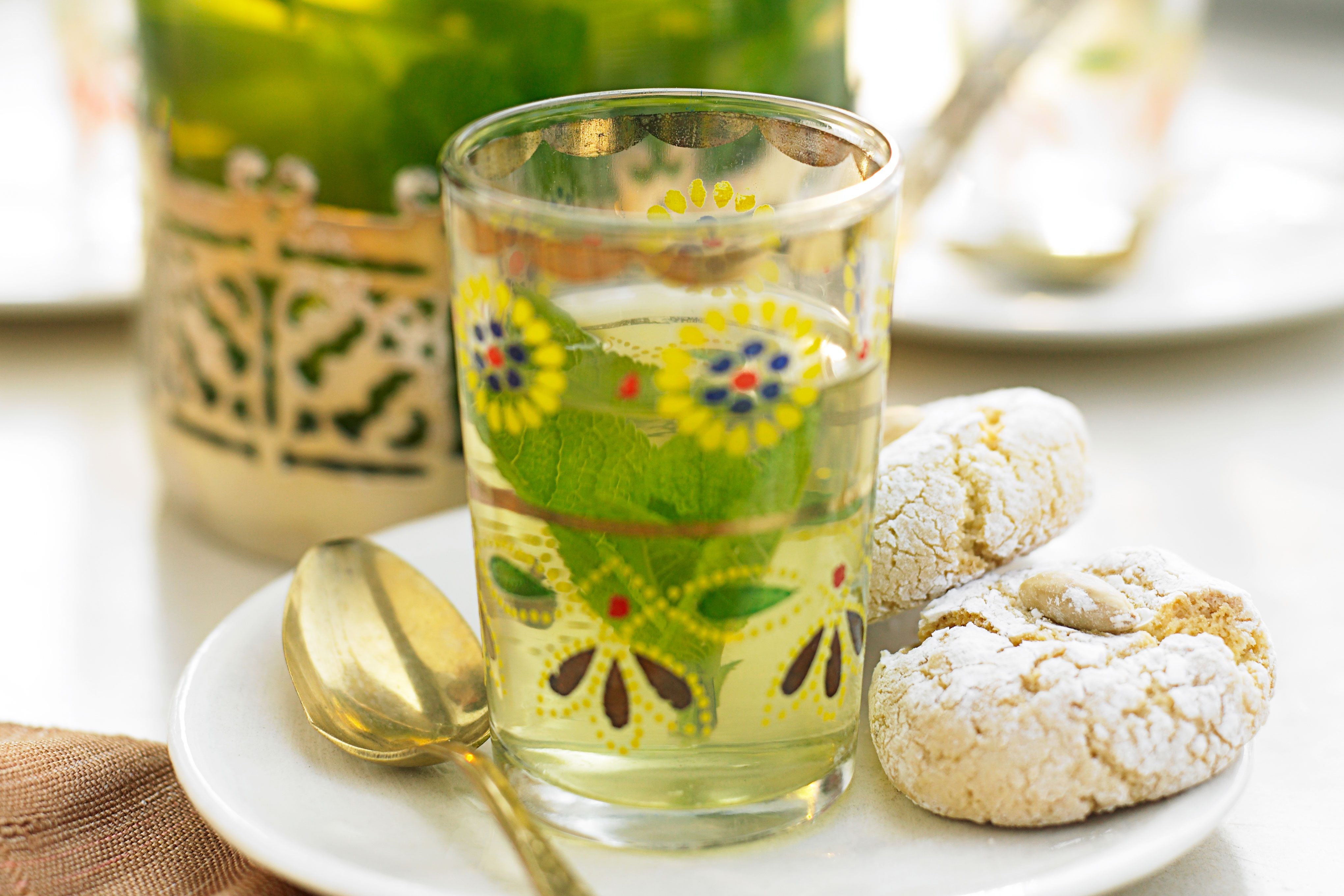 A glass of mint tea with biscuits, the quintessential Moroccan beverage.