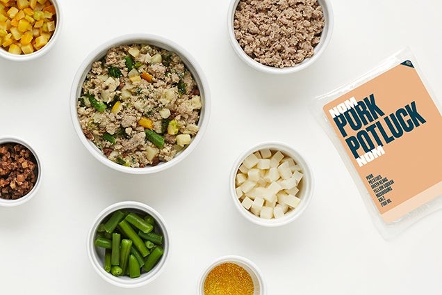 Nom Nom fresh dog food, shown in a bowl surrounded by the product