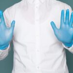 A worker wearing blue nitrile gloves while preparing food