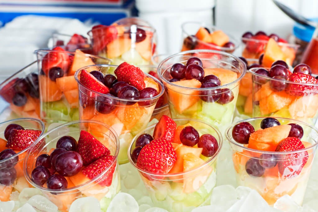 Fruits served on ice at an outdoor event, demonstrating a refreshing and visually appealing way to keep food chilled, enhancing the overall party experience.