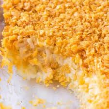 Pan of funeral potatoes made of hash browns and sour cream with crispy topping.