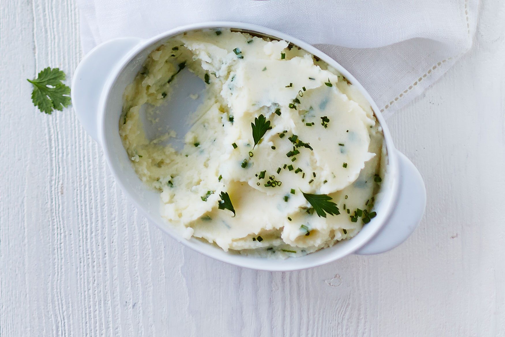 Oval dish of garlic mashed potatoes with a serving removed