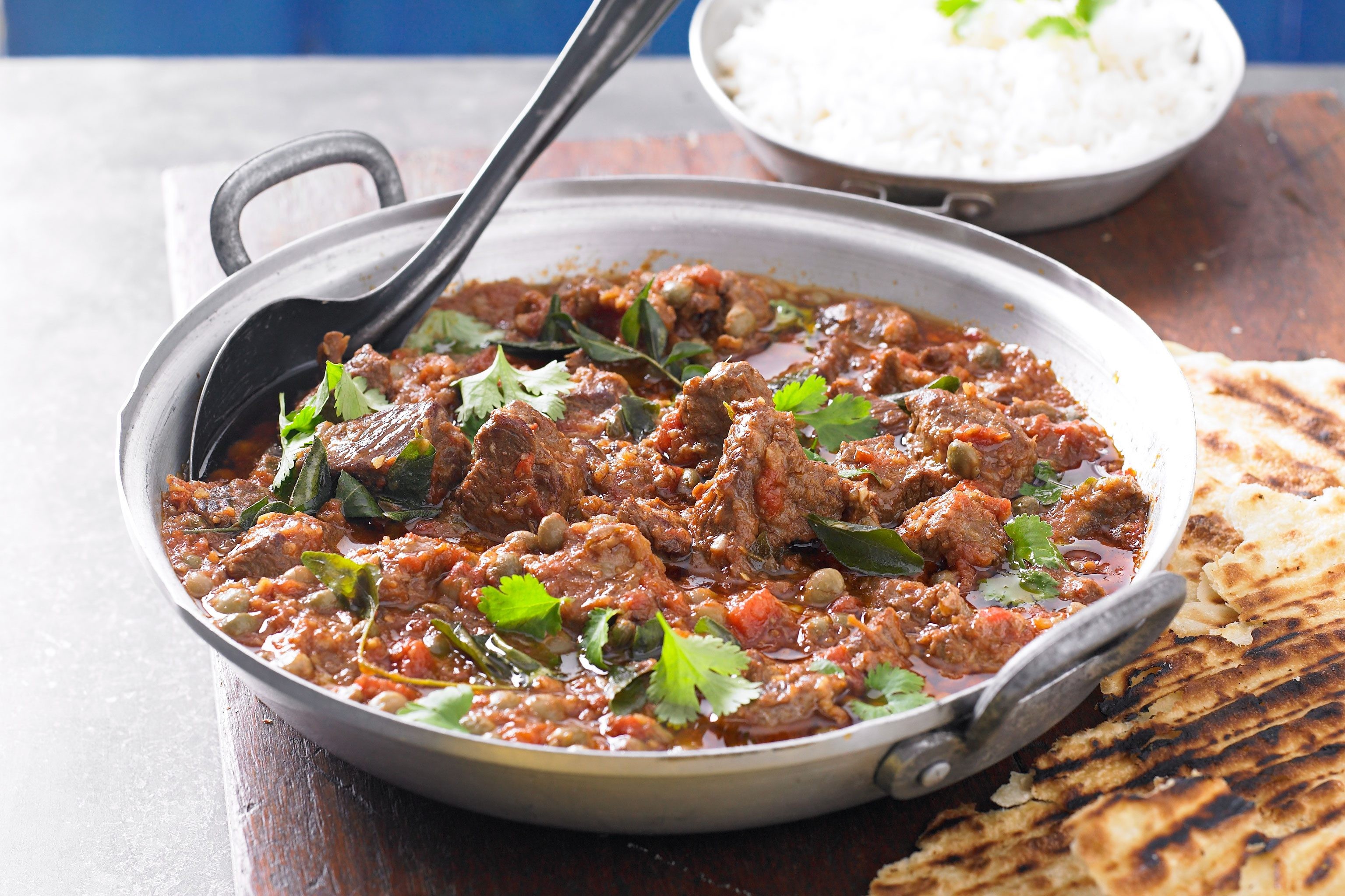 Pan of goat curry with coriander on top