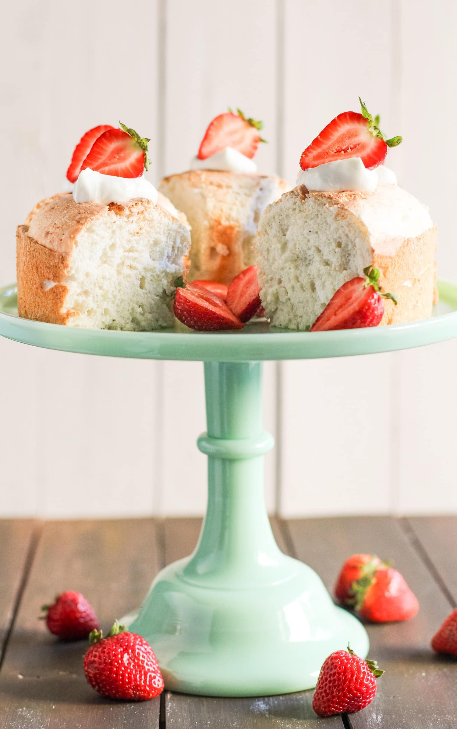 Close up of a slice of healthy angel food cake with fresh strawberries on top